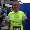 Runner giving thumbs up at race event.